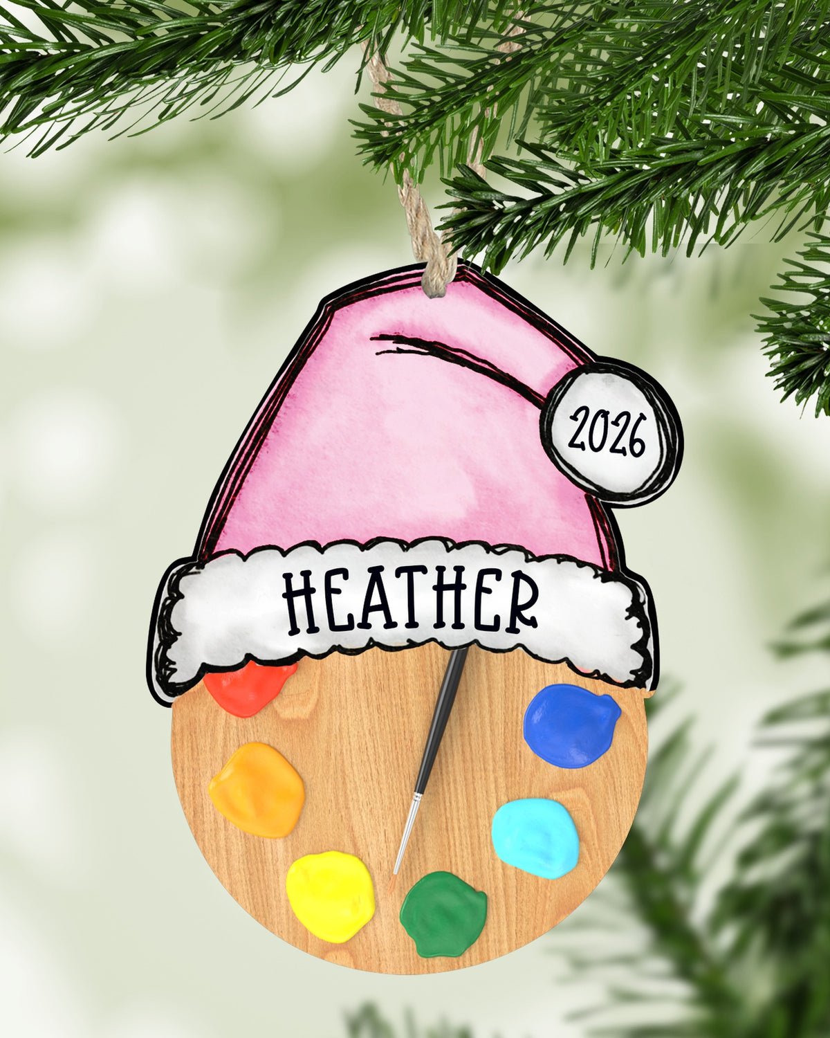 Personalized artist palette Christmas ornament hanging on a Christmas tree - The Painted Pug
