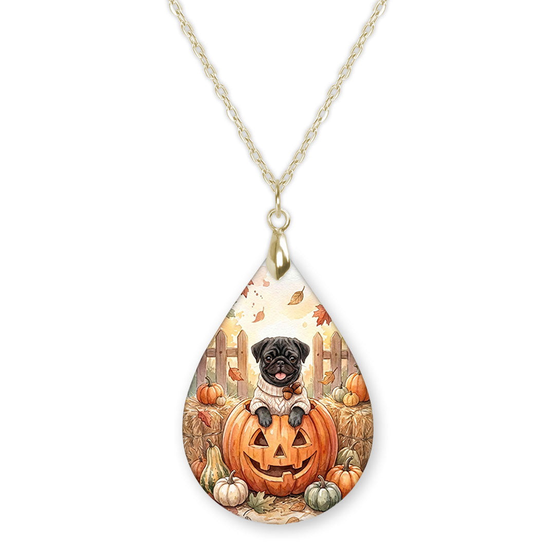 Black pug in a jack-o-lantern teardrop necklace on a gold chain