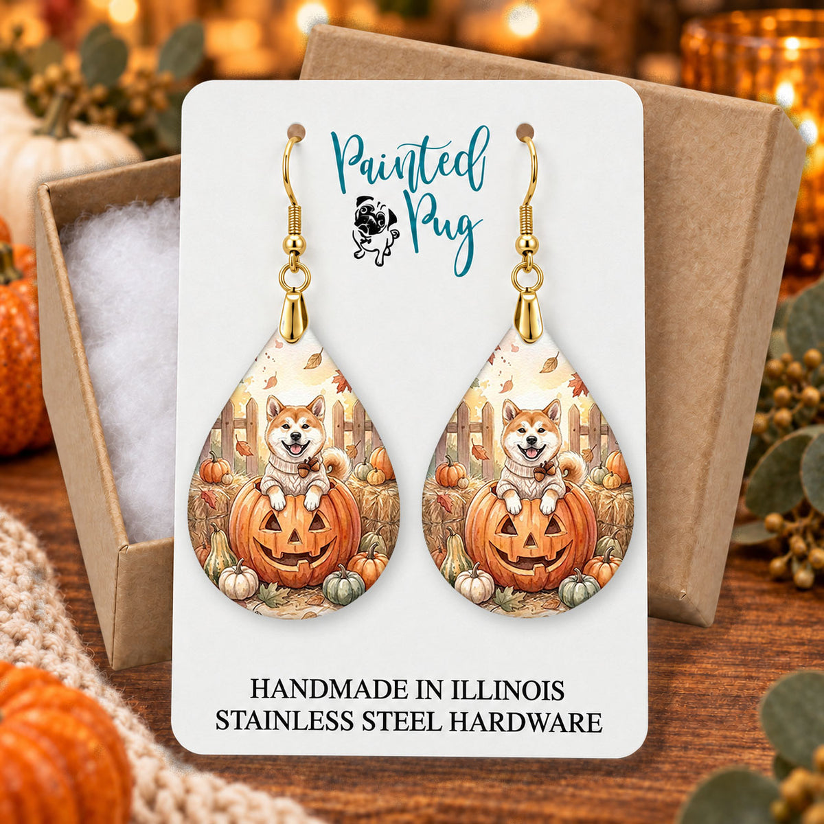 Akita pumpkin teardrop earrings gift boxed on a cozy fall background