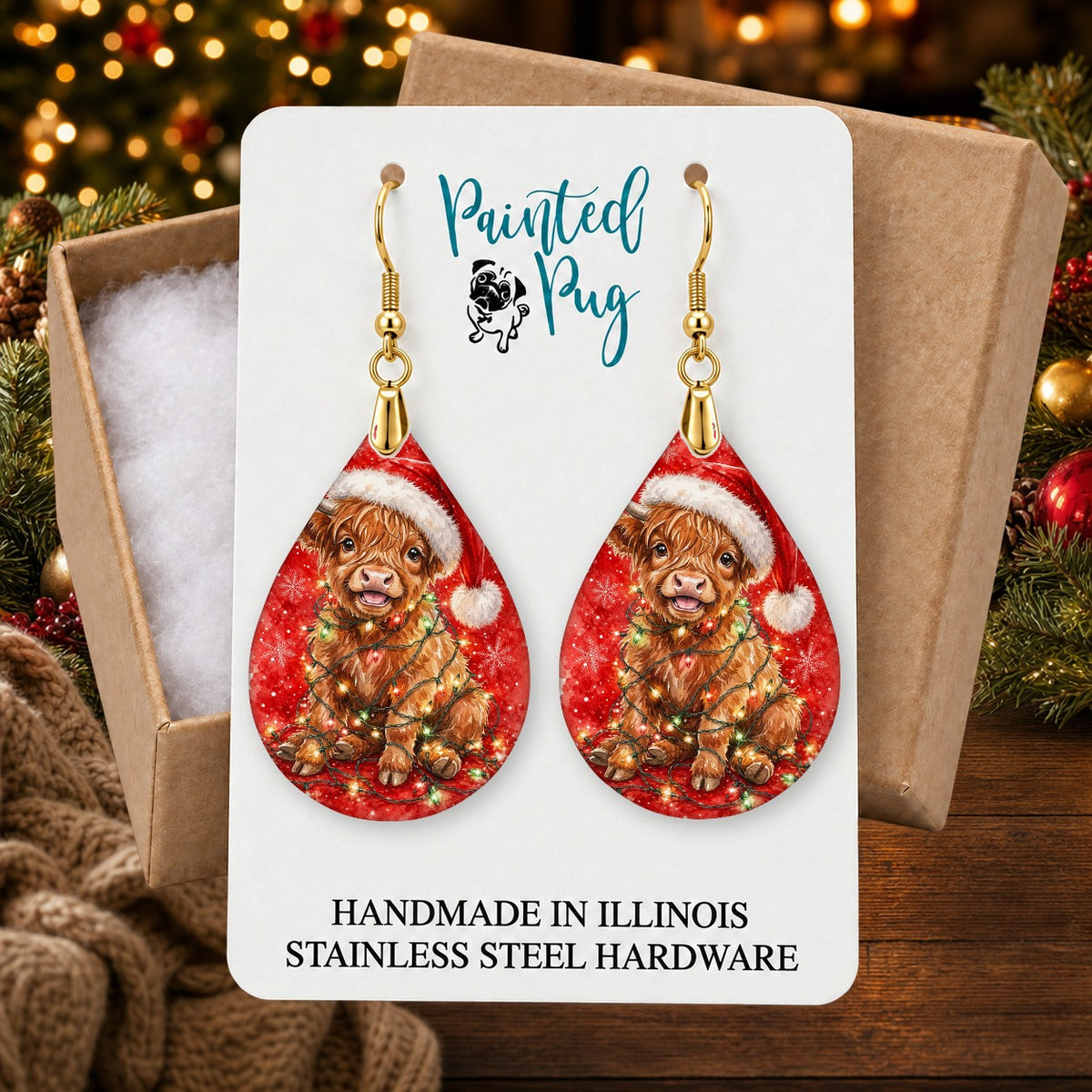 Highland Cow Christmas Lights earrings in a gift box on a Christmas table