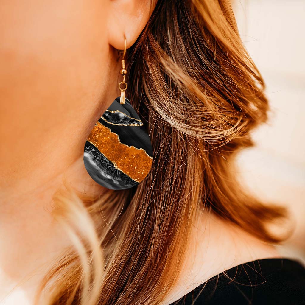 Model wearing a black and orange agate teardrop earring