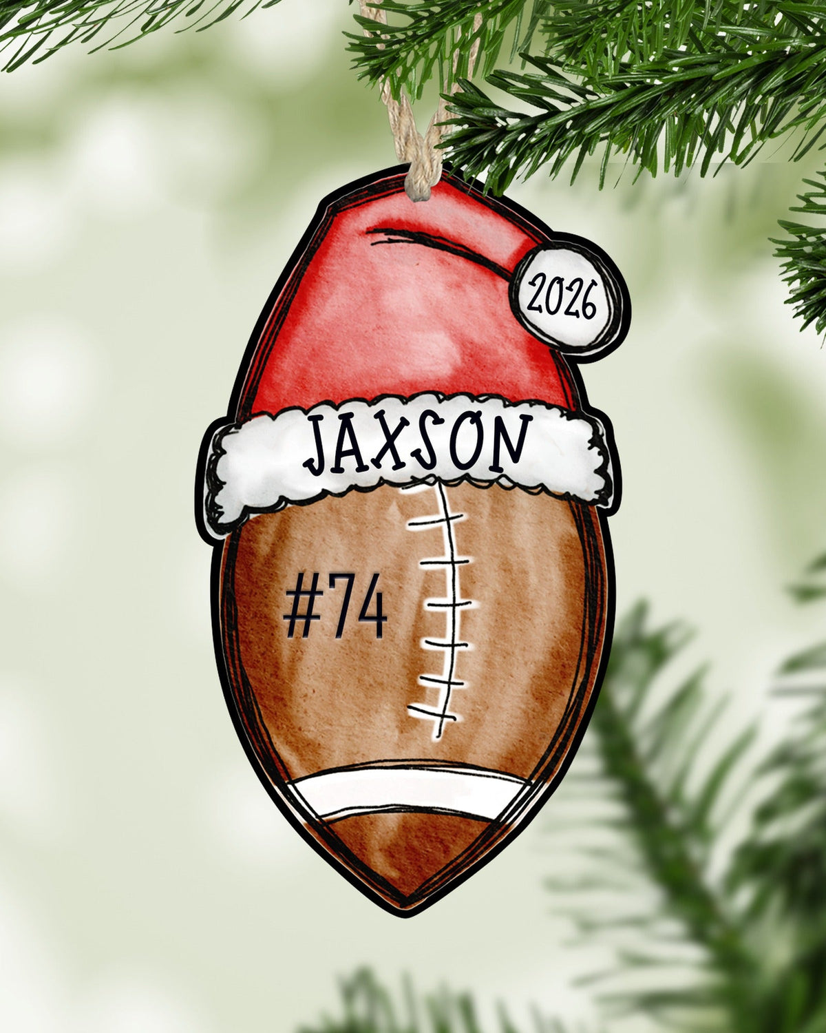Personalized football Christmas ornament hanging on a Christmas tree - The Painted Pug