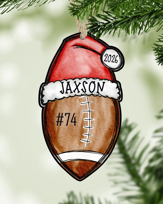 Personalized football Christmas ornament hanging on a Christmas tree - The Painted Pug