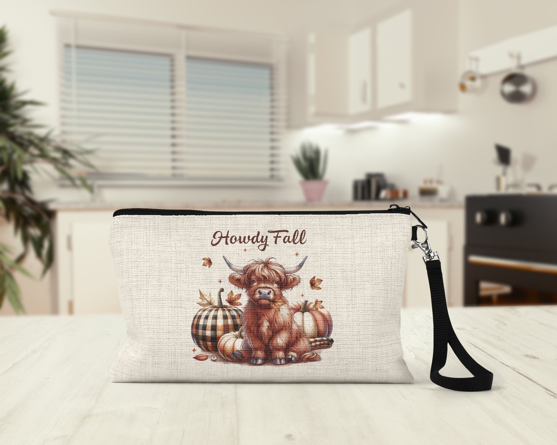 Howdy Fall Highland Cow Makeup Bag on a kitchen counter