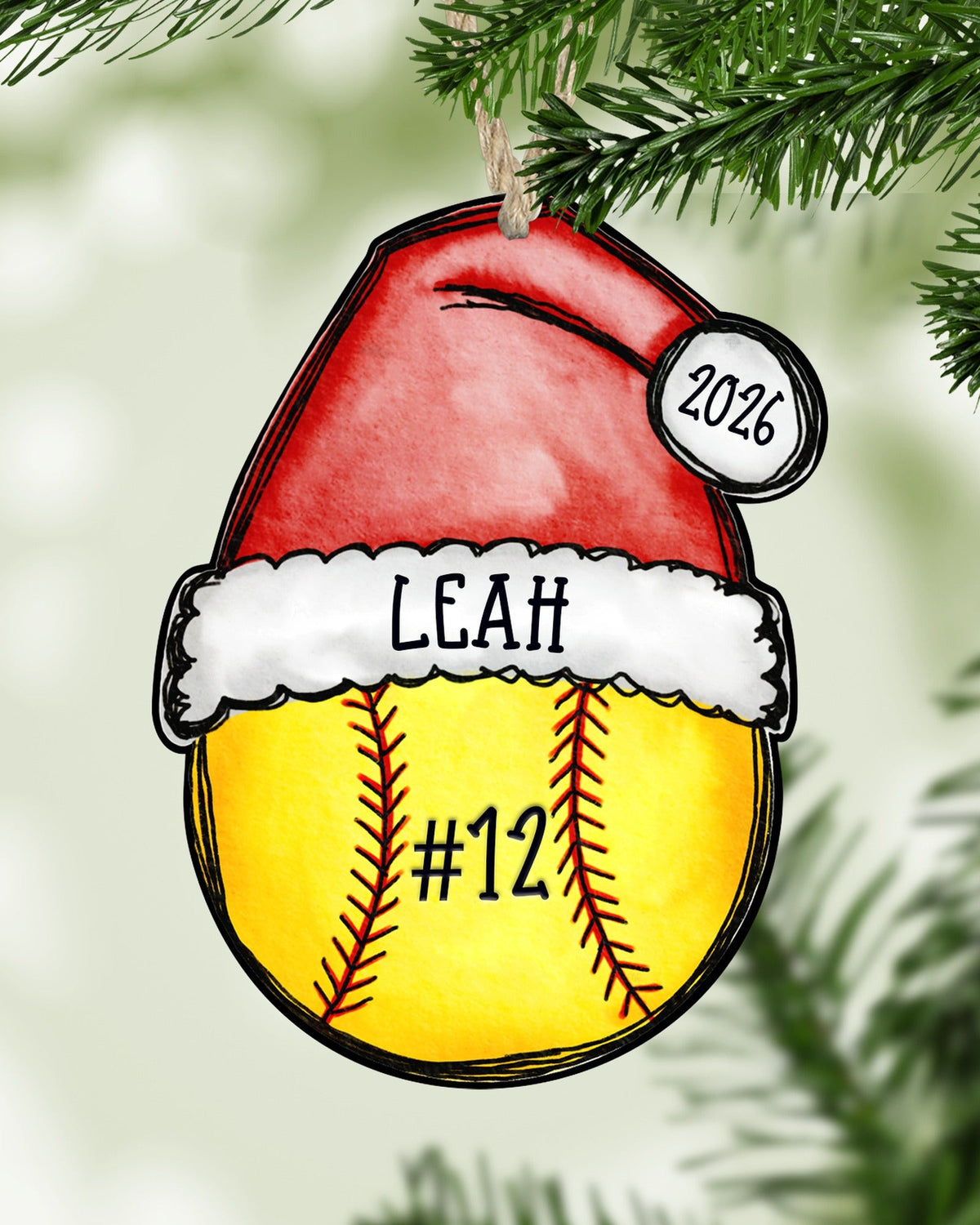 Personalized softball Christmas ornament hanging on a Christmas tree - The Painted Pug